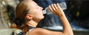 chica joven hidratándose bebiendo agua en verano