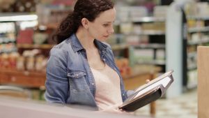 mujer leyendo un cuaderno en una tienda
