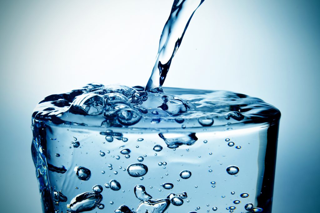 Agua mineral cayendo en vaso