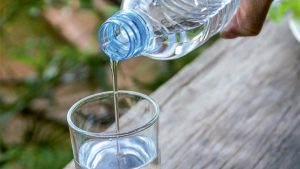 agua en una botella con ecodiseño llenando un vaso